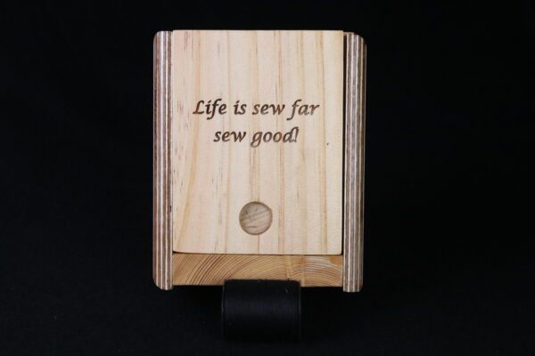 A wooden plaque with the words life is sew far, sew good.