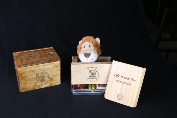 A stuffed animal sitting in front of some wooden boxes.