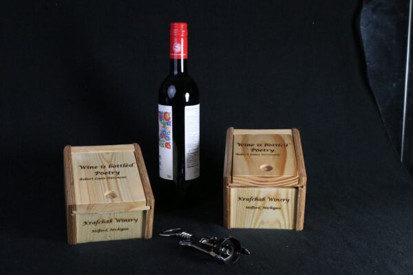 A bottle of wine and two wooden boxes.